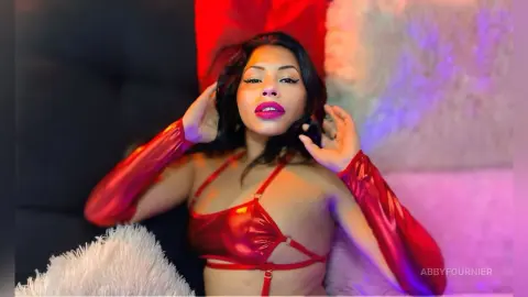 Glamorous woman in a red metallic bikini set posing on a soft white faux fur surface with a romantic mood.