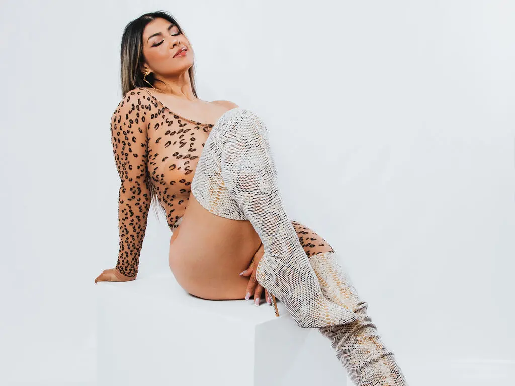 Fashionable woman in leopard print bodysuit and white knit over-the-knee boots posing against a white background.