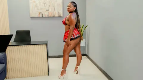 Confident woman in a red plaid bikini and white platform heels posing in a modern minimalist room.