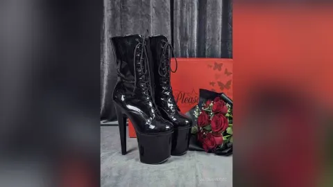 AlienaMoore — AlienaMoore displays a pair of black patent leather platform boots next to a bouquet of red roses.