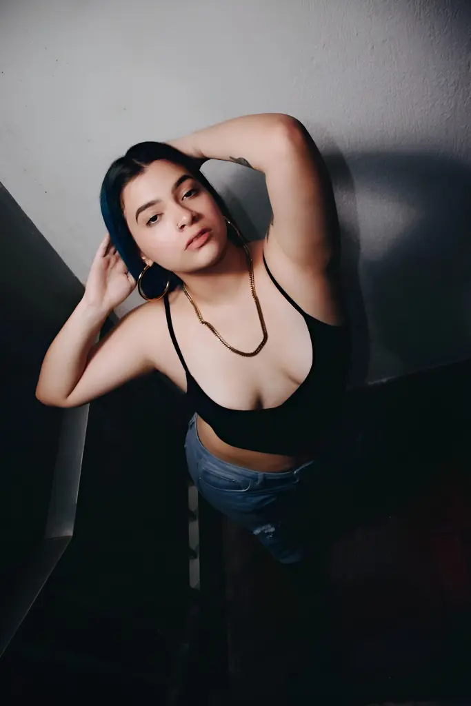 SophiaCyrus101 poses with her long blue-tipped hair, wearing a low-cut grey bra or top against a dark night background.