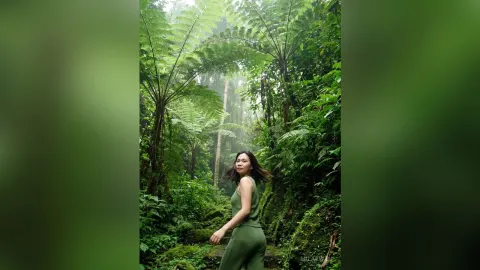MilaSwan — MilaSwan poses in a green sleeveless outfit amidst lush tropical ferns and forest greenery.