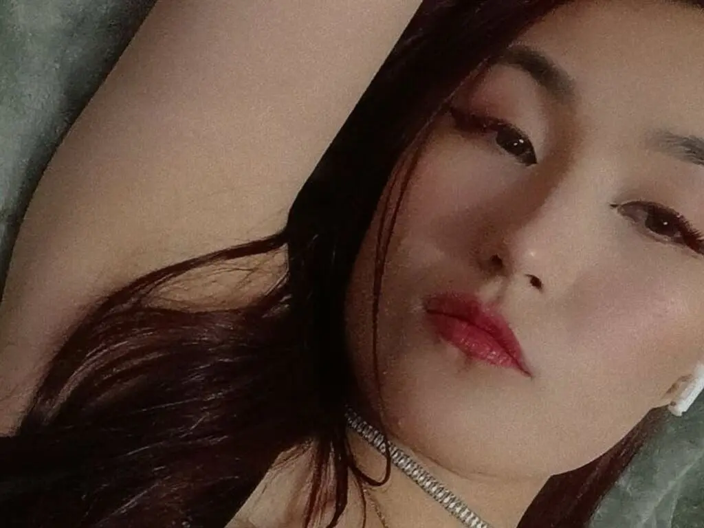 MaragaretSvedine looks into the camera with long dark hair and red lipstick while lying down.