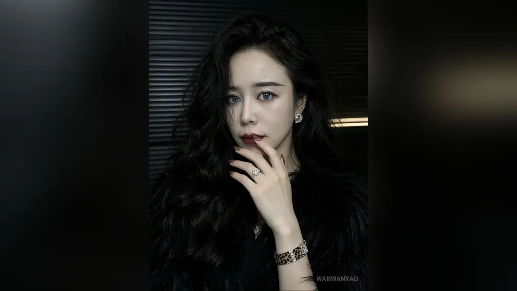 WanwanYao — WanwanYao poses with long wavy black hair and dark red lipstick against a dark background.