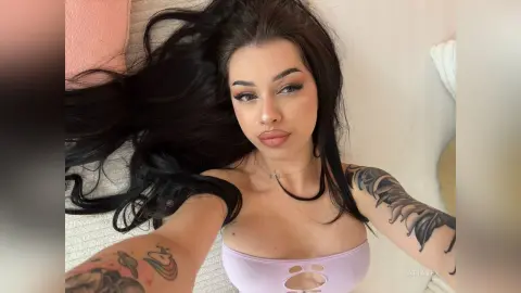 AriaVex lies back with her long black hair spread out, wearing a light purple cut-out top and a thin black choker.