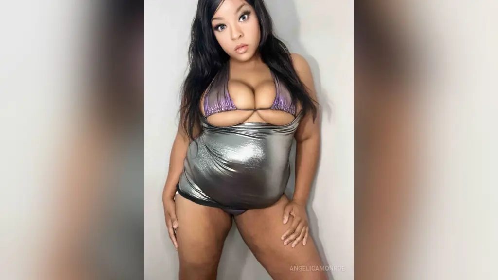 Curvy woman in a shimmering silver metallic dress posing against a white background with a glamorous mood.