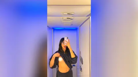 VeronicaValdez holds a phone for a mirror selfie, lifting a black shirt to show her bare breast and stomach.
