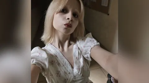JillianOng — JillianOng wears a white floral print top while looking into the camera with a pouty expression.