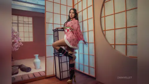 Young woman in a pink floral kimono posing in a traditional Japanese room with shoji screen doors.