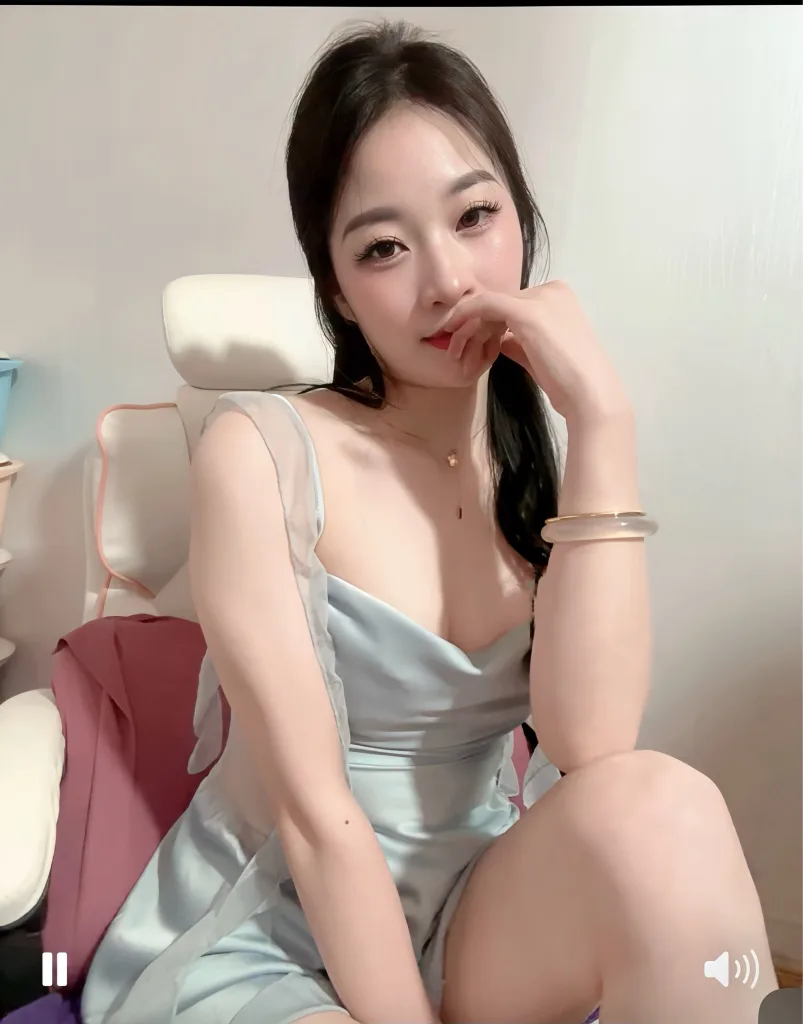 Young woman in a white strapless top posing against a soft pink background with glowing fairy lights.