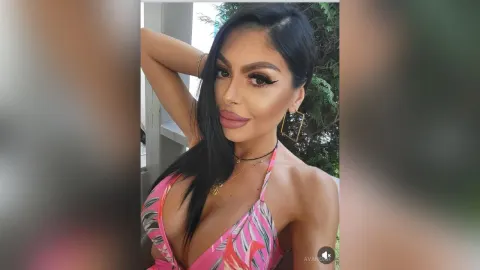 AvaNoah — AvaNoah poses outdoors in a pink patterned bikini top with her hand behind her head.