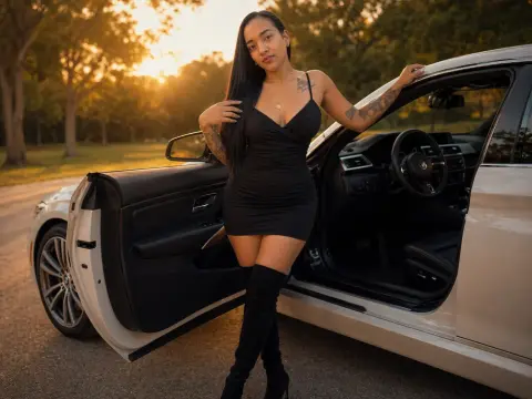 Stylish woman in a black mini dress and over-the-knee boots posing by a luxury car at sunset.