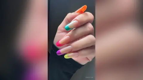 Close-up of long coffin-shaped nails with vibrant multi-colored ombre polish in pink, green, and yellow hues.