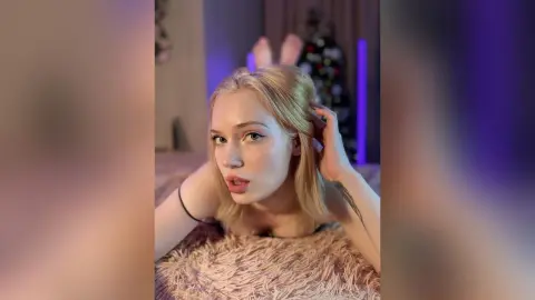 Blonde woman in black lingerie relaxing on a plush rug in a moody, purple-lit bedroom setting.