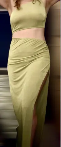 CurvyHannahXX poses in a tight, light green crop top and matching long skirt with a high slit.