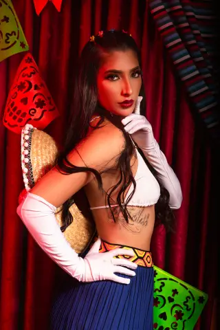Glamorous woman in white gloves and bikini top posing against red curtains for a vintage aesthetic photoshoot.