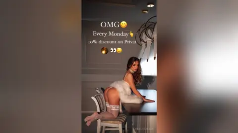 Glamorous woman in white lingerie sitting on a chair in a modern, moody indoor setting.