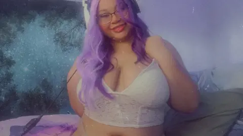 Smiling woman with long purple hair wearing a white lace crop top in a dreamy, starlit bedroom setting.