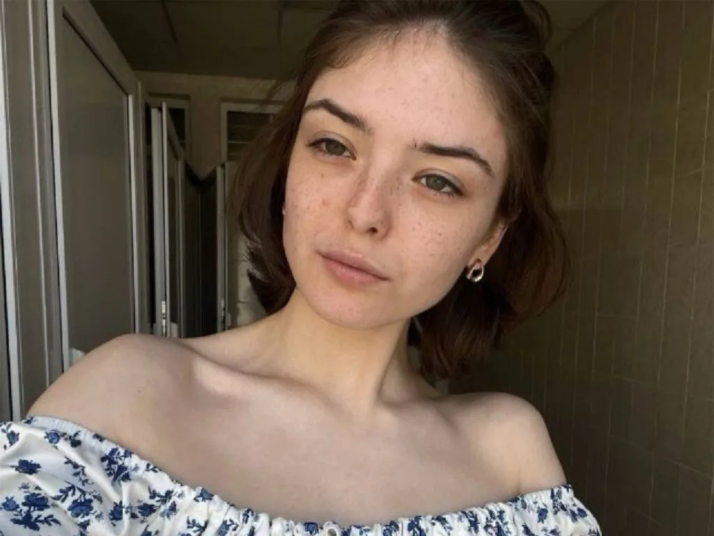 UshaSolgovic looks at the camera wearing an off-the-shoulder blue and white floral top.