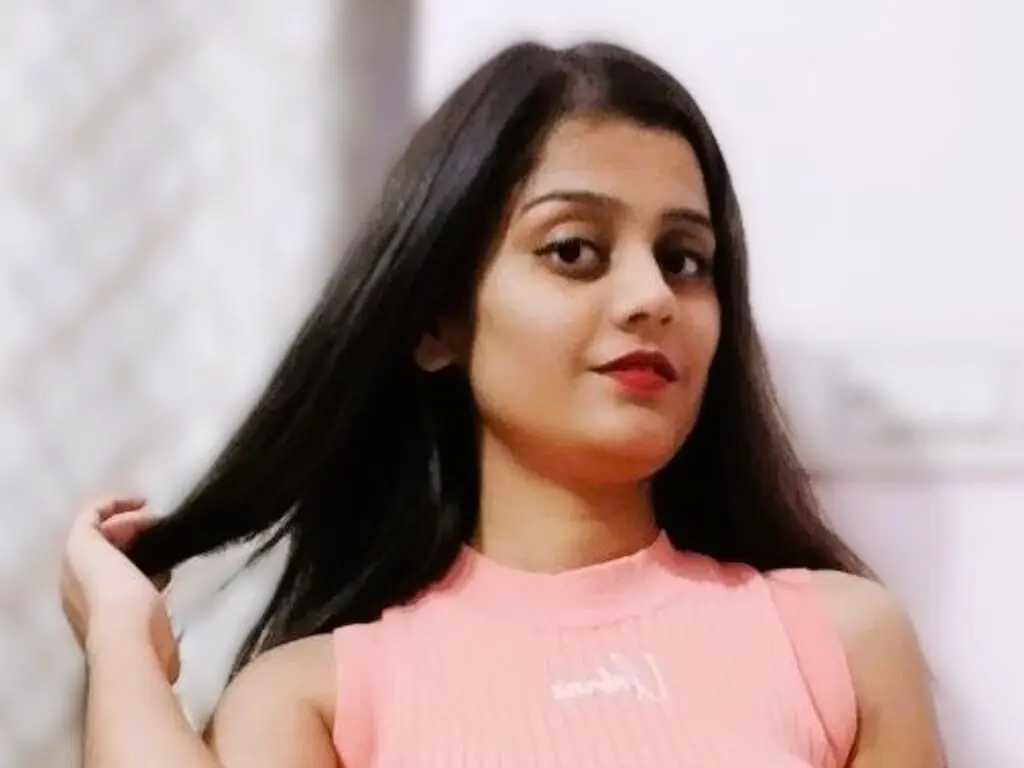 DeanerySnow — DeanerySnow with long dark hair wears a pink sleeveless top while looking at the camera.