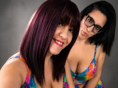 Sinfulmarkedqueens and her friend pose together in colorful patterned sundresses with dark hair and red lipstick.