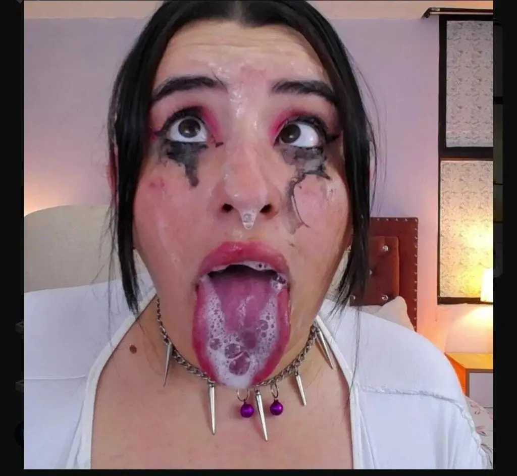 leidyswallow wears a black t-shirt and looks into the camera with pink eyeshadow and glossy lips.