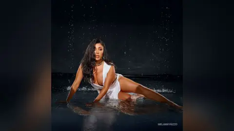 Glamorous woman in a white dress posing in a dark water setting with a moody, cinematic atmosphere.