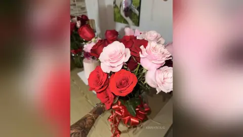 Beautiful bouquet of red and pink roses in a vase on a wooden table creating a romantic mood.