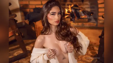 Beautiful woman in a cozy white sweater relaxing by a warm fireplace in a rustic home setting.