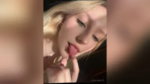 Blonde woman in a casual top making a playful expression in warm, soft sunlight.