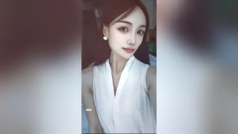 Elegant young woman in a white sleeveless blouse posing with a serene expression in a soft-lit indoor setting.