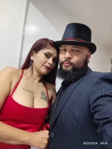 Elegant couple in formal attire, woman in red satin dress and man in black suit and top hat, romantic mood.