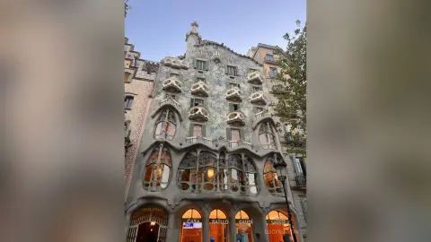 LucyMartin poses in front of the organic, stone-carved facade of Casa Batlló in Barcelona.