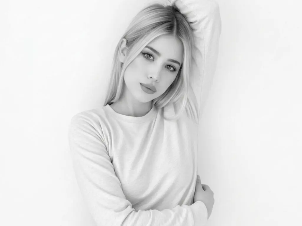 Blonde woman in a white long-sleeve shirt posing against a minimalist white background with a serene mood.