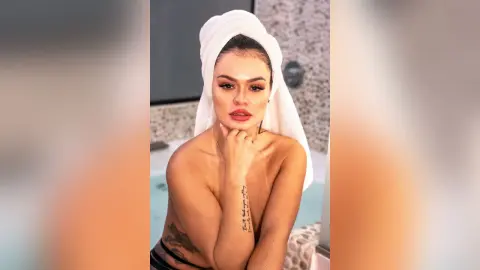 ErikaHoffman poses naked with a white towel wrapped around her head, showing her bare shoulders and chest.