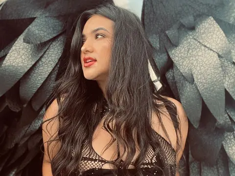 Beautiful woman with long dark hair wearing a black sequin outfit and large black feathered wings.