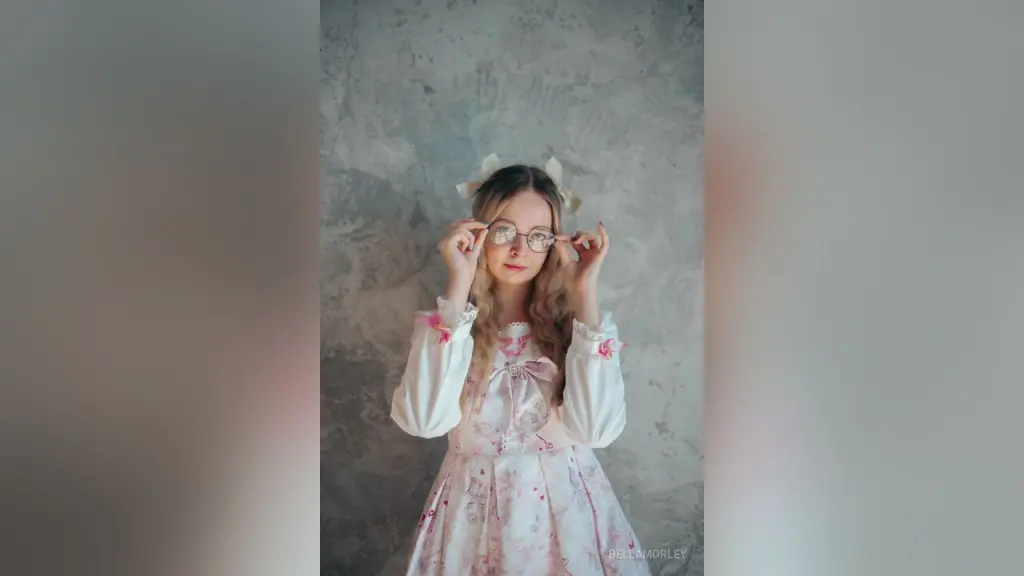Dreamy portrait of a blonde girl with glasses and hair bows wearing a white vintage lace blouse.