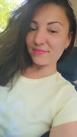 FoxyKara smiles for a selfie wearing a pale yellow t-shirt and a gold necklace.