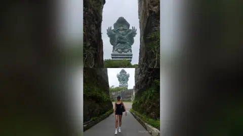 Woman in black tank top standing on a path before a massive ancient stone statue in a lush jungle setting.