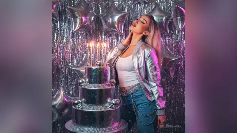 Glamorous woman in silver jacket celebrating birthday with cake and star balloons in a festive disco setting.