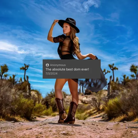 Stylish woman in a black dress and hat posing in a sunny desert landscape under a bright blue sky.