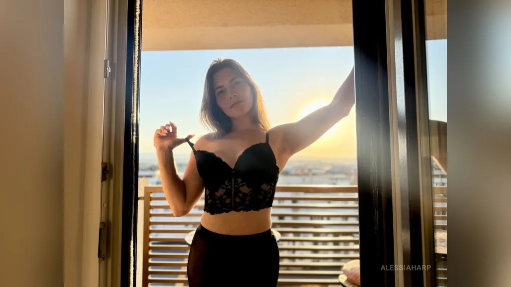 AlessiaHarp — AlessiaHarp poses in black lace lingerie on a balcony during a golden sunset.