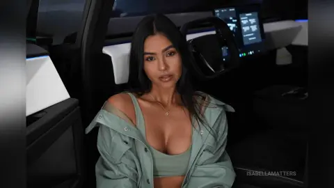Young woman in a sage green outfit sitting inside a modern car with a moody, cinematic aesthetic.