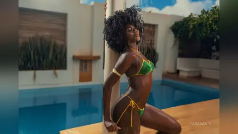 Beautiful Black woman in a green bikini relaxing by a luxury poolside under a refreshing outdoor shower.