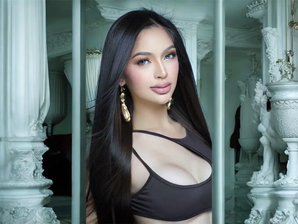 Beautiful woman with long dark hair in a black crop top posing in a luxurious white classical interior.