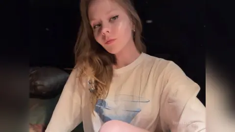 SophiePeachy poses for a selfie wearing a white t-shirt with long blonde hair.