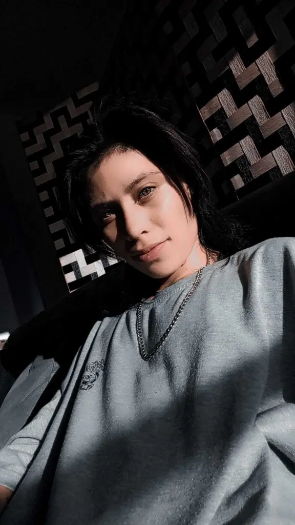 Morgan_Evans_t has wet black hair and a slight smile, showing her teeth and a small piercing on her bottom lip.