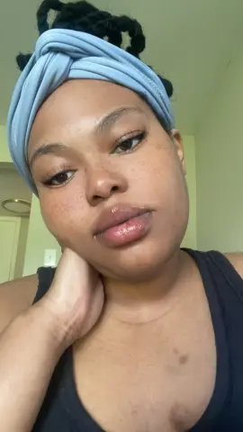 MilfArie22 wearing a light blue headband and black tank top, posing with her hand under her chin.