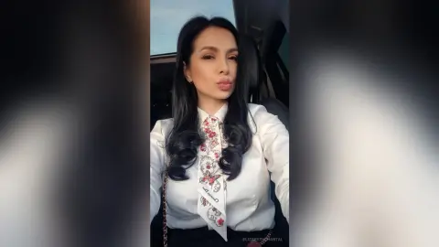 ElizabethChantal — Elegant woman in a white floral blouse sitting in a car with a soft, moody aesthetic.