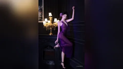LunaWen — LunaWen poses in a sheer purple dress against a dark wall next to a gold lamp.